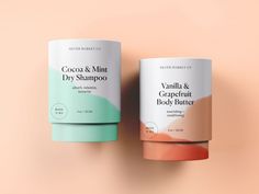 two jars of cocoa and mint dry shampoo on a pink background, one is green and the other is orange