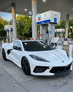 a white sports car parked at a gas station