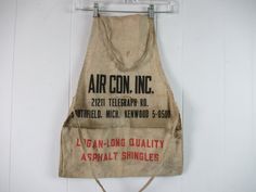 an old apron hanging on a wall with the words air con inc written on it