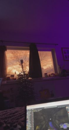 a laptop computer sitting on top of a desk in front of a purple lit room