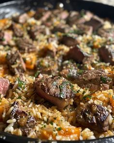 a pan filled with meat and rice on top of a table