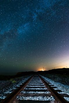 a train track with the sky in the background and stars above it that says, tus sueros te esperan, ve por ellos