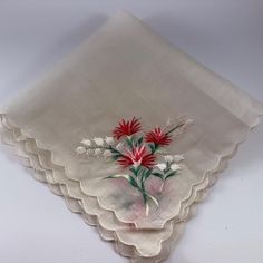 three napkins with red and white flowers on them