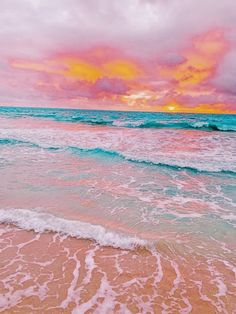 the sun is setting over the ocean with pink and blue waves crashing in to shore