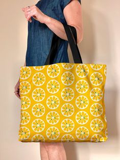 "Meet my Lemon Grid handbag, a yellow lined oversized canvas beach bag, travel bag or market bag great for summer, gym, travel... this bag has a zillion uses. Check out the handy wallet sized pockets on the inside, the bag is fully lined with a snap closure. This colorful bag is a great girlfriend or hostess gift, mostly I'm seeing folks nab them for theirselves (encouraged!) Made to order. The original artwork is designed here in my studio, and printed, hand sewn and shipped directly to you from the printer when ordered. Printing time is about a week, our vendor is in Montreal, the quality is excellent. Deets: * Cotton Pebble Canvas - sturdy, natural, has a great feel * 20\" wide, 15\" tall and 4\" deep - extra room to fit all the things * Navy blue inner liner with 1 zipper pocket and 1 Summer Gym, Canvas Beach Bag, Yellow Handbag, Vegan Travel, Yellow Line, Colorful Bags, Fruit Print, Cotton Tea Towels, Canvas Handbags