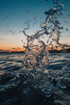 water splashing on top of the ocean at sunset