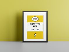 a penguin book cover sitting on top of a table next to a framed poster that says country life