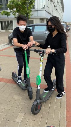 two people on scooters wearing face masks