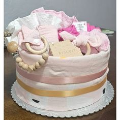 a pink and gold baby gift basket sitting on top of a table