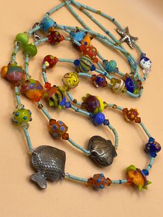 "Handmade Vintage Lampwork Glass Sterling Silver \" Under The Sea \" Artisan One Of A Kind Necklace . Each bead has attention to detail with many sterling touches . This beautiful ocean themed necklace has 3 large sterling beads ( Fish, Shell, & Starfish) the lobster claw clasp is 925 Silver . Please remember all items are vintage & estate found, therefore do not expect perfection as they may show some wear or imperfections only adding to the character & authenticity. All items are identified and described as accurately as possible with all information on hand at the time the listing was made. no expertise is claimed on any items for sale. Thank You" Bohemian Handmade Murano Glass Necklaces, Bohemian Handmade Murano Glass Necklace, Artisan Glass Jewelry With Large Beads, Bohemian Glass Jewelry With Single Strand, Bohemian Glass Single Strand Jewelry, Beach Jewelry With Large Glass Beads, Bohemian Single Strand Glass Jewelry, Adjustable Multicolor Ocean-inspired Necklaces, Unique Murano Glass Beaded Necklaces For Jewelry Making