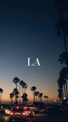 cars driving down the road at night with palm trees in the background and la written across the image