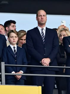 a man in a suit and tie standing next to two boys with their arms crossed