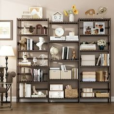 a living room filled with lots of bookshelves next to a chair and lamp