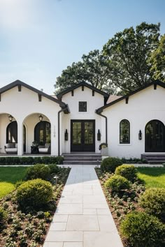 One story ranch style home with white exterior and black trim and details. Beautiful landscaping lineing path leading up to front door. New Construction Exterior, Spanish Colonial Exterior, Landscaping Front Porch, Hacienda Interior Design, Spanish House Exterior, Hacienda Interior, Modern Spanish Home