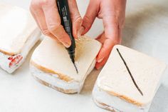 a person cutting into sandwiches with a knife