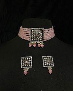 Women's Silver Plated pendant jewelry - Pink Bridal Choker Set & Earrings of CZ crystals A silver-plated choker with pink onyx drops adorns this bridal choker necklace. Contemporary ladies' bridal set with multilayered bead strands choker and Kundan gemstone earrings. This bridal choker jewelry set is accented with pink onyx & Kundan pendant making it one of a kind. The pendant of a square-shaped design is studded with CZ crystals & Pink Onyx. This contemporary choker is sure to make you feel li Jeweled Crystal Jewelry In Diamond White, Silver Jeweled Cubic Zirconia Jewelry Sets, Silver Cubic Zirconia Jeweled Jewelry Sets, Silver Bridal Necklace With Crystal Stones, Silver Crystal Bridal Necklace With Stones, Silver Jeweled Choker For Wedding, Silver Pendant Jewelry With Stone Work, Silver Pendant Bridal Necklace For Reception, Silver Jewelry With Sparkling Stones For Reception