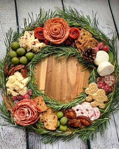 a wreath made out of different types of food on a wooden table with pine cones