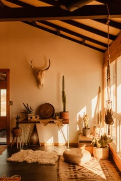 a living room filled with lots of furniture next to a wall mounted deer head on the wall