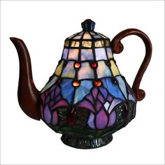 a stained glass teapot is shown with red and blue lights on the top, as well as a brown handle