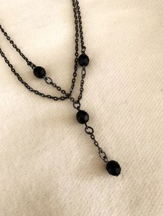 This black bead necklace has two 16" chains.  On one of the chains hangs an extra 1 3/4 inch extension with 2 of the 4 beads.  It has a nice sturdy clasp and is sure to please! Thank you for considering my items! So How Can I Say This Vintage Item Has Never Been Worn??? Most of the jewelry I sell is from a warehouse/business buy-out purchased from a retired jewelry wholesaler who did business from the 1970s thru the 1990s --- so has never been worn or sold at retail - only stored!  Much of this Black Double Strand Necklace For Party, Black Dangle Clavicle Chain Jewelry, Black Metal Double Chain Necklace, Elegant Black Double Strand Layered Necklace, Black Double Chain Necklace As Gift, Black Double Chain Necklace For Gift, Black Layered Necklace With Adjustable Chain As Gift, Black Metal Jewelry With Ball Chain, Black Double Strand Beaded Necklaces For Jewelry Making