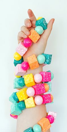 a hand is holding several candy bars in different colors