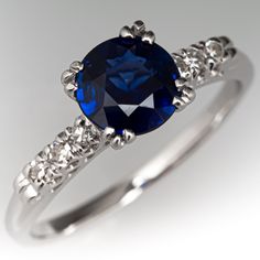 This captivating ring is centered with one (1) round mixed cut natural sapphire set into a four-split prong style setting. The shoulders of the ring are each accented with three (3), prong set, round single cut diamonds. The ring measures 6.6mm at the top, rises 5.8mm above the finger, tapering to 1.6mm wide and 1.2mm thick at the base of the shank. This ring is currently a size 6.75. The mounting shows gentle side wear. Blue Sapphire Engagement Ring, Sapphire Engagement Ring Blue, Sapphire Engagement Ring, Sapphire Engagement, Natural Sapphire, Engagement Rings Sapphire, Jewelry Rings Engagement, Prong Setting, Sapphire Ring