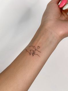 a woman's arm with a small tattoo on the left side of her wrist