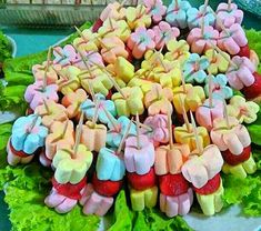 a platter filled with marshmallows and strawberries on top of lettuce