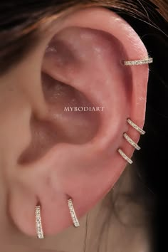 a woman's ear with three rows of diamond bar earrings on top of it