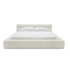 a bed with white sheets and pillows on it