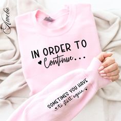 someone is holding up a pink shirt that says in order to continue