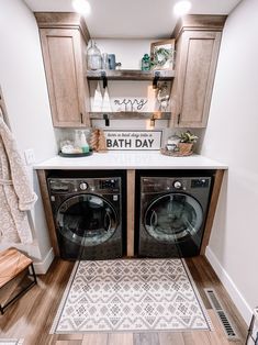 a washer and dryer in a small room with wooden cabinets on the wall