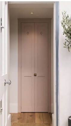 an open door leading into a room with white walls and wood flooring on either side