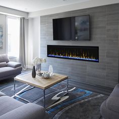 a living room with a couch, coffee table and television mounted on the wall above it