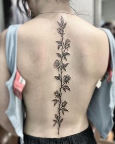 a woman's back tattoo with flowers on it