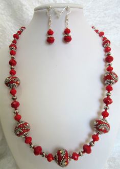 "Beaautiful handmade beads from Indonesia are blended with red opaque crystals and pewter accents to make this unique 20\" necklace. The lobster clasp is silver plated. A three inch extender is added. The earrings are red opaque crystals with silver plated ear wires. They dangle 3/4\" from the loop. This set will be wrapped in tissue and placed in an organza bag." Red Czech Glass Jewelry With Spacer Beads, Red Beaded Czech Glass Jewelry, Red Czech Glass Jewelry With Faceted Beads, Red Czech Glass Jewelry With Polished Beads, Jewelry Set Red, Irish Cross, Gold Sand, Crystal Jewelry Sets, The Lobster