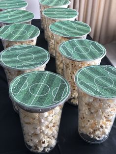 several plastic cups filled with popcorn sitting on top of a black cloth covered tablecloth