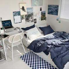 a bedroom with a bed, desk and computer on the wall next to each other