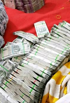 stacks of money sitting on top of a bed covered in blankets and scarves next to each other