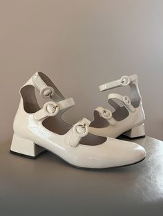 I LOVE these adorable shoes! They would not be listed if these were my size, that's for sure. From the Jeffrey Campbell line (original item listing https://jeffreycampbellshoes.com/products/recital?variant=41558756917313). Adjustable straps climb up the vamp and wrap around the ankle of a glossy pump framed by a squared-off toe and modest block heel. An easy shoe to dress up for a night out or pair with something casual for day wear. Gently used with some very light scuffing, but as you can see from the photos it isn't anything super obvious. Size 6.5. Original retail price $200. Retro Pointed Toe Mary Janes For Spring, Spring Patent Leather Mary Janes With Ankle Strap, Spring Patent Leather Mary Janes With Flat Heel, Retro Low Heel Mary Janes For Spring, Spring Patent Leather Mary Janes With Low Heel, White Patent Leather Mary Jane Heels, Spring Patent Leather Mary Janes With Block Heel, White Block Heel Mary Janes For Spring, White Pumps