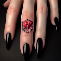 a woman's hand with black fingernails and red heart shaped ring on her finger