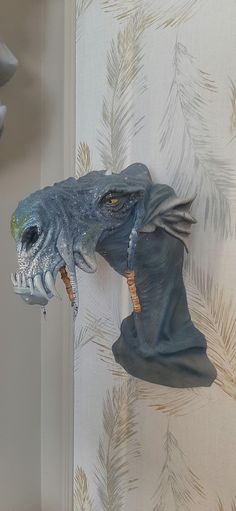 a blue dragon head hanging from the side of a wall