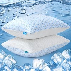 two pillows sitting on top of each other in the water next to ice cubes