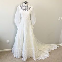 White Lace Embroidered Mock Neck Wedding Gown. Mock Neckline With Sheer Lace Upper And Embroidered Florals. Long, Sheer Puffed Sleeves With Embroidered Button Snap Cuffs. Gathered Waist, A-Line Silhouette, Back Zipper Closure. There Is No Size Listed Measurements - Shoulder To Shoulder 14.5", Pit To Pit 15.5", Waist 12.5" Pit To Wrist 19", Shoulder To Wrist 24", Hip 27" No Major Flaws, Stains, Marks Or Holes Tags: Wedding, Gown, Dress, Victorian, Romantic, Cottage Core, Bohemian, Lace, Fashion Embroidered Fitted Floor-length Wedding Dress, Formal White Gown With Floral Embroidery, Fitted White Gown With Floral Embroidery, Full-length Embroidered Wedding Gown, Fitted Embroidered Wedding Dress For The Bride, Embroidered Fitted Wedding Dress For Bride, Fitted Wedding Gown With Floral Embroidery, Fitted Floral Embroidered Wedding Gown, Fitted Floral Embroidery Wedding Gown