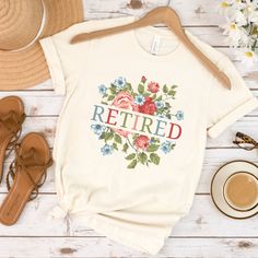 a t - shirt with the words retired on it next to some shoes and flowers