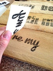 a person is holding a piece of paper with writing on it in front of some wooden boxes