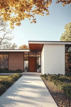 a modern house with white walls and wood accents on the front door is surrounded by greenery