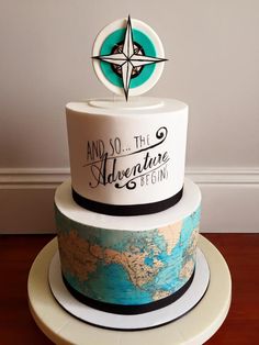 a three tiered cake with a compass on top