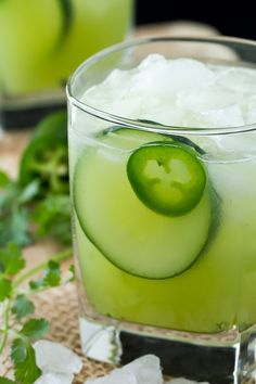 a cucumber drink in a glass with ice and garnish