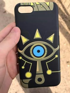 a person holding up a phone case with an eye on it